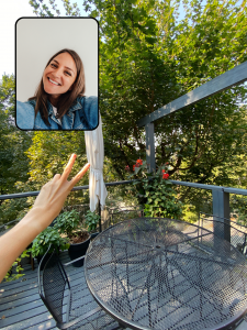 A photo of a hand doing a peace sign on an outdoor patio surrounded by trees. In the top left corner, another photo of a woman taking a selfie is overlaid.